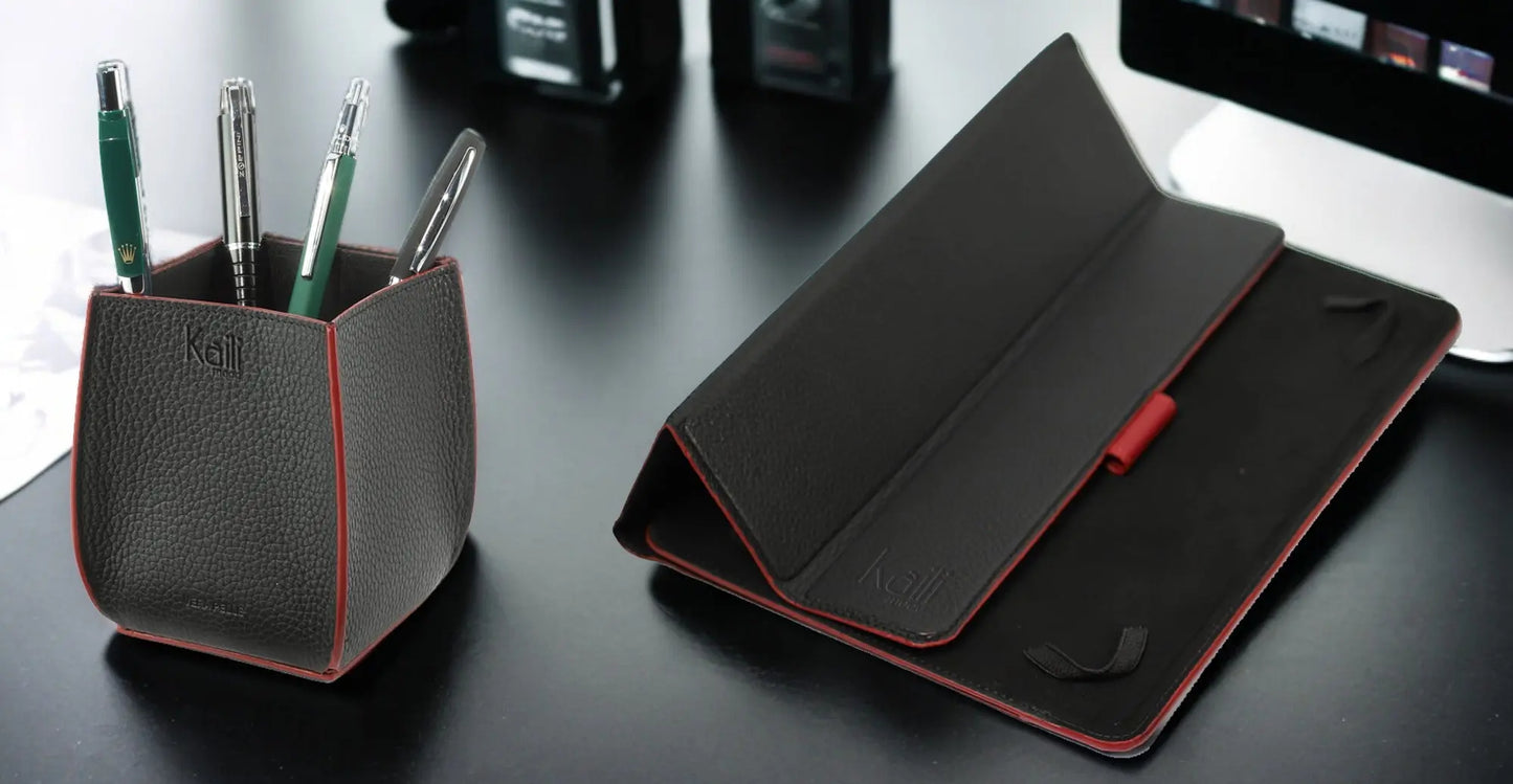 K0032AB | Pot à crayons en cuir véritable pleine fleur grain dollars. Coloris noir avec bords rouges. Dimensions : 8,5 x 8,5 x 12 cm. Conditionnement : coffret cadeau fond/couvercle